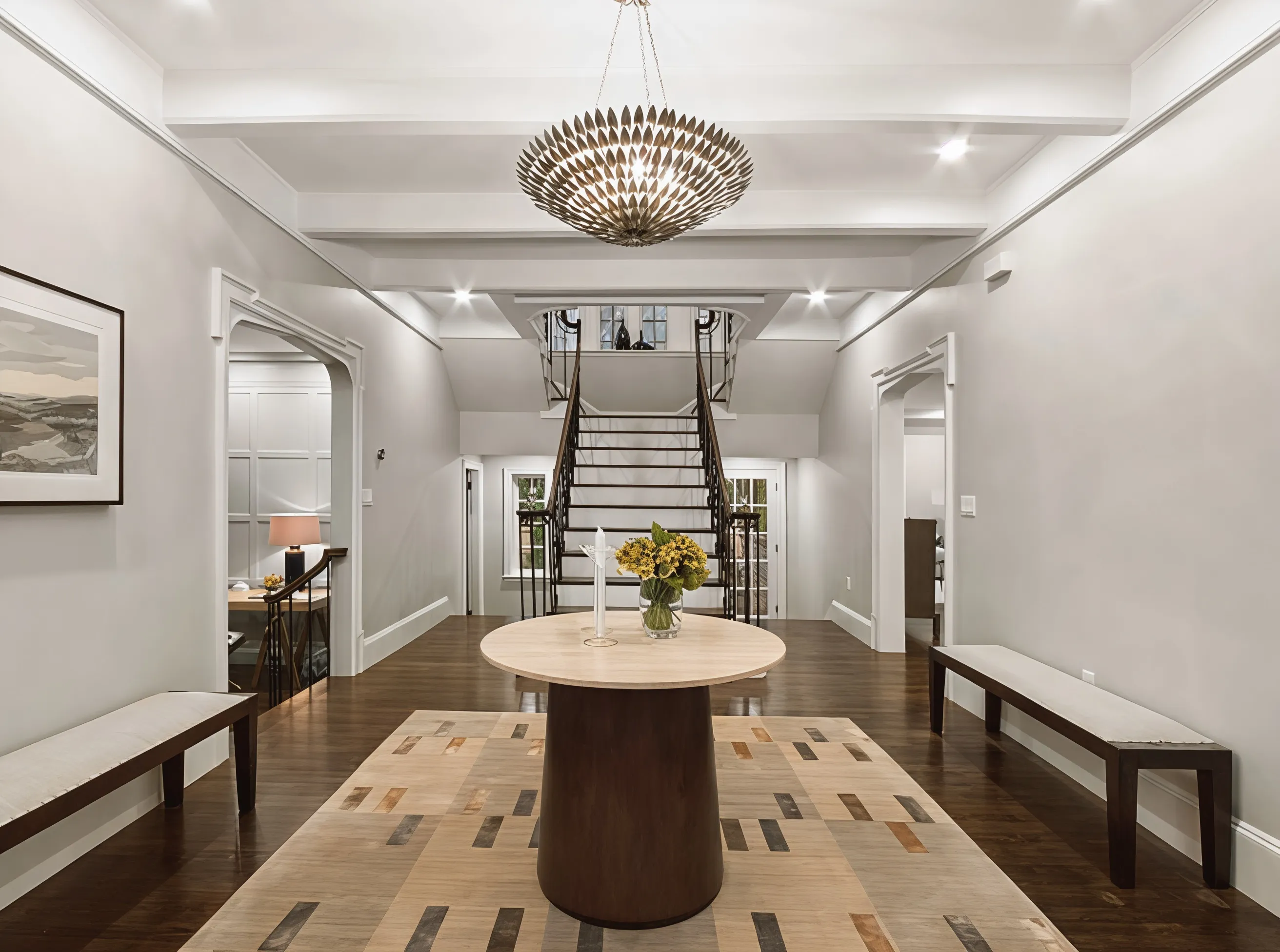 Grand entry foyer with wrought-iron staircase and coffered ceiling, a recent Abrams Builders restoration in Chestnut Hill